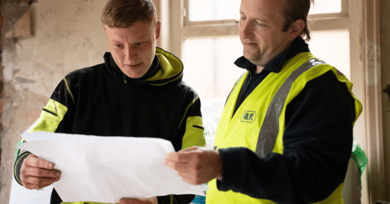 Two construction workers looking at building plans