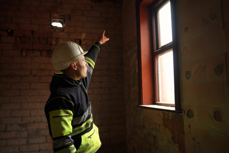 Construction worker planning a wall for retrofitting.