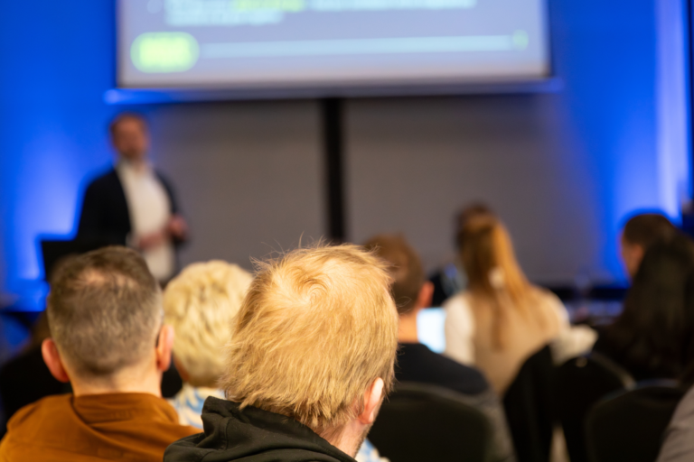 A presentation room with people sat down listening to how to choose their right NVQ or construction training.