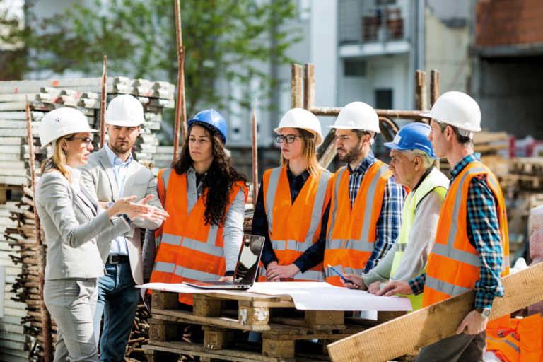 A group of construction learners gathered around a building site training.